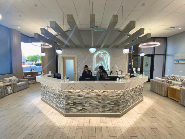 View of front desk in lobby with two customer service representatives behind the front desk.